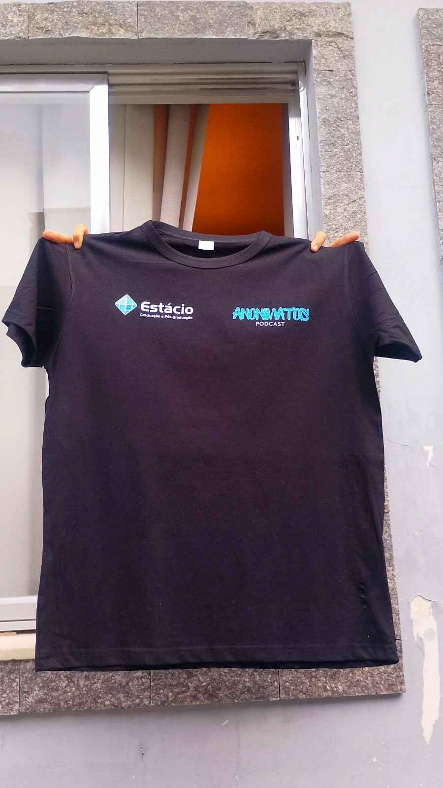 Camisa personalizada em tom escuro com identidade institucional.